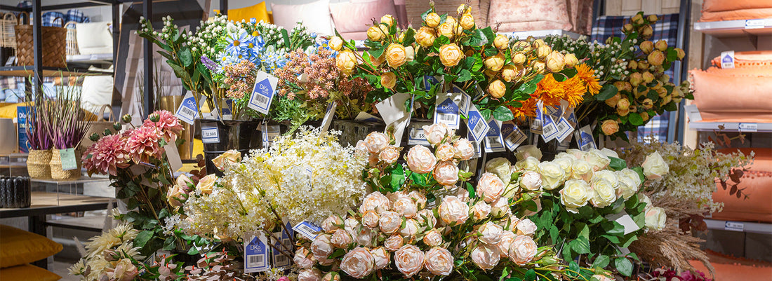 Arreglo de plantas y flores artificiales en maceteros decorativos