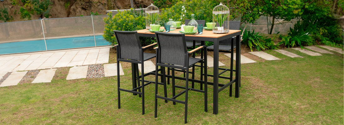 Terraza con mesa alta de bar y sillas altas