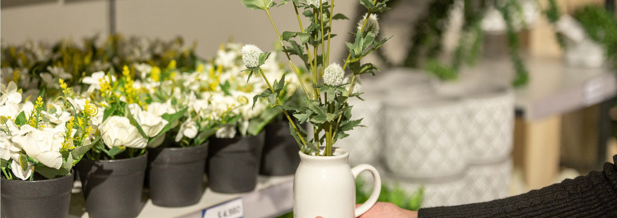 Plantas artificiales en maceteros sobre muebles de living